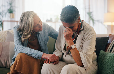 Woman, crying and holding hands in home with friends, support or compassion for healing from grief.
